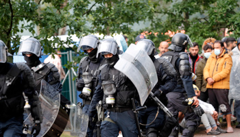 Riot police face migrants protesting against living conditions at the tented camp at the Rudninkai former air base training ground, Lithuania, August 2 (TOMS KALNINS/EPA-EFE/Shutterstock)