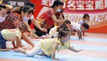 Parents and their babies participate in a baby crawling contest at a shopping centre in Beijing (Xinhua/Shutterstock)