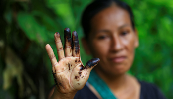 An indigenous woman shows oil residues on her hand, following a pipeline rupture, August 2020.  (Jose Jacome/EPA-EFE/Shutterstock)