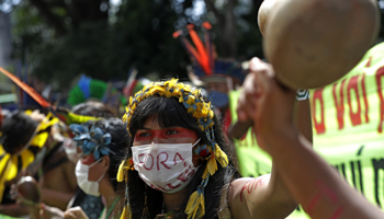 An indigenous woman participates in a protest against proposals to allow mining on indigenous lands. Brasilia, Brazil, April 2021 (Eraldo Peres/AP/Shutterstock)