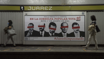 Commuters walk past a poster encouraging citizens to participate in a referendum on whether ex-presidents should be investigated for alleged corruption. Mexico City, July (Christian Palma/AP/Shutterstock)