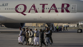 Taliban fighters walk past a Qatar Airways plane at Kabul airport, September 9 (Bernat Armangue/AP/Shutterstock)