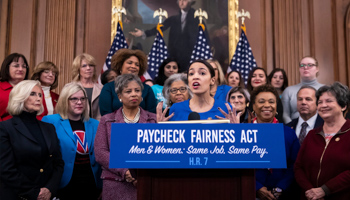 Lilly Ledbetter, Alexandria Ocasio-Cortez. Rep. Alexandria Ocasio-Cortez, D-N.Y., joined at far left by Lilly Ledbetter, an activist for workplace equality, speaks at an event to advocate for the Paycheck Fairness Act on the 10th anniversary of President Barack Obama signing the Lilly Ledbetter Fair Pay Act, at the Capitol in Washington, January 2019 (J Scott Applewhite/AP/Shutterstock)