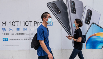 Pedestrians walk past the Xiaomi Mi 10T Pro 5G smartphone advertisement at its flagship store in Hong Kong (Budrul Chukrut/SOPA Images/Shutterstock)