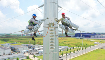 Construction workers on a power supply line in Anhui province (Shutterstock)