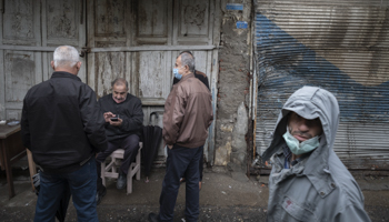 Iranian men sitting outside a closed shop, Anzali, October 9 (Morteza Nikoubazl/NurPhoto/Shutterstock)
