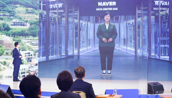 South Korean President Moon Jae-in (facing screen, R) listens to a report by Naver Corp CEO Han Seong-sook, projected in real time on a screen, July 14, 2020 (Yonhap/EPA-EFE/Shutterstock)