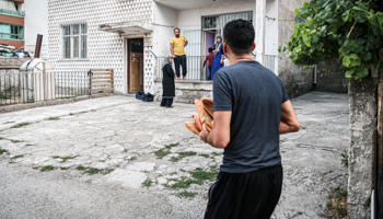 Volunteers distribute bread to refugees penned in their homes by locals, after a man died in hospital following a fight between a Syrian group and residents in the Battalgazi neighbourhood of Ankara, August 12 (Tunahan Turhan/SOPA Images/Shutterstock)