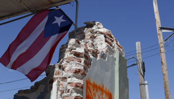 A Puerto Rican flag flies from a building damaged in the January 2020 earthquake (Thais Llorca/EPA-EFE/Shutterstock)