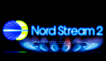 Kazan, Russia - Nov 23, 2021: Nord Stream 2 is system of offshore natural gas pipelines in Europe, running under Baltic Sea from Russia to Germany. Gas burner on background of Nord Stream 2 logo.; (Shutterstock / Sergei Elagin)