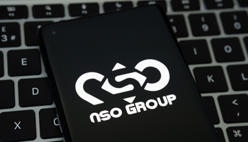 NSO Group logo on a smartphone placed on Apple Macbook laptop keyboard (Shutterstock / mundissima)