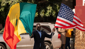 A man waves Senegalese and US flags as Secretary of State Blinken leaves the Ministry of Foreign Affairs in Dakar, Senegal, November 20 (Andrew Harnik/AP/Shutterstock)