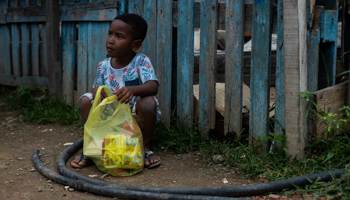 A child with a food parcel donated by the NGO COVID Without Hunger in Rio de Janeiro (Bruna Prado/AP/Shutterstock)