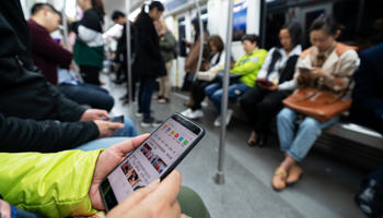 A Chinese commuter using their smartphone in Chengdu (Shutterstock / B.Zhou)