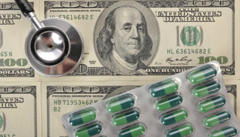 A stethoscope and medical capsules lie on US dollar banknotes (Michael Weber/imageBROKER/Shutterstock)