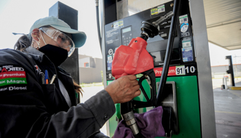 A petrol station worker cleans a petrol pump in Mexico City. April, 2020 (Carlos Tischler/Shutterstock)
