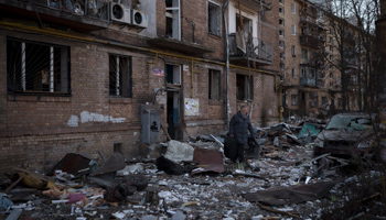 A Kyiv resident carries his belongings after his apartment block was damaged in a Russian strike, March 18 (Felipe Dana/AP/Shutterstock)