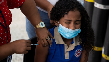 A girl receives a dose of vaccine against COVID-19 at a school in the Dominican Republic. February 14 (Orlando Barria/EPA-EFE/Shutterstock)