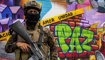 A soldier stands next to a mural that reads "peace" at a checkpoint in a neighbourhood of San Salvador. March 29 (Camilo Freedman/SOPA Images/Shutterstock)