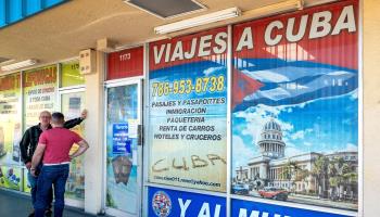 Two people stand in front of an agency offering Cuba travel and cargo services in Florida. May 17, 2022 (Cristobal Herrera-UlashkevichEPA-EFE/Shutterstock)