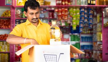 Neighbourhood store shopkeeper packing groceries for e-commerce delivery, India (Shutterstock)