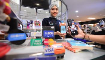A customer using digital payment technology at a bookshop in Kediri, Indonesia (Shutterstock)