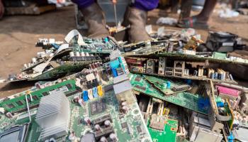 A worker dismantles desktop computer waste in Ghana (Muntaka Chasant/Shutterstock)