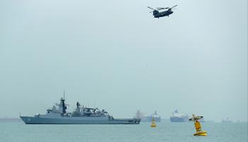 KD Lekiu (FFG30) of the Royal Malaysian Navy and a Republic of Singapore Air Force Chinook helicopter during the Five Power Defence Arrangements 50th anniversary fly-past and naval sail-past off Singapore's Marina South last October (Lionel Ng/SOPA Images/Shutterstock)

