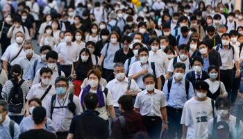 People wearing protective masks walk towards Shinjuku railway station (Kimimasa Mayama/EPA-EFE/Shutterstock)