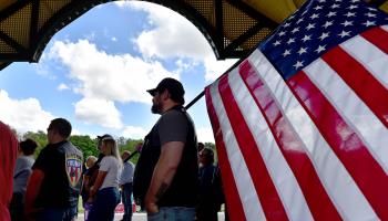 A man holds a US flag at a Republican rally in Wilkes-Barre, Pennsylvania, May 13, 2022 (Aimee Dilger/SOPA Images/Shutterstock)