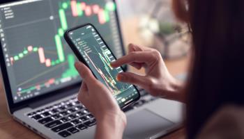 Investor checking Bitcoin price on her smartphone (Shutterstock)