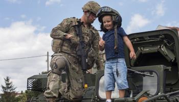 A US soldier poses for a picture with a Macedonian child in the city of Kumanovo (Georgi Licovski/EPA/Shutterstock)
