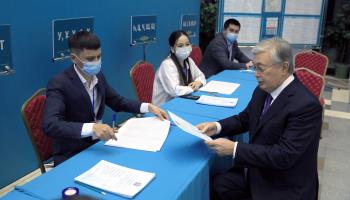 President Kassym-Jomart Tokayev reviews his ballot paper before voting in an election which he wins (Xinhua/Shutterstock)