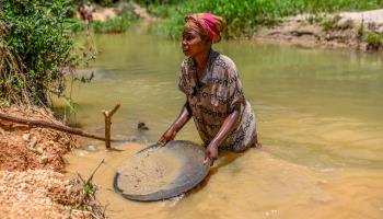A Malagasy woman pans for gold (Paul Grover/Shutterstock)