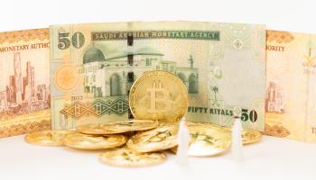 Saudi Arabian riyal notes and Bitcoin (Shutterstock)