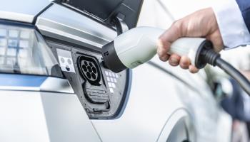 Person plugging in an electric car (Shutterstock)