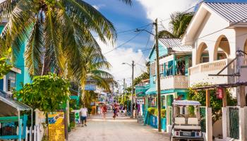 People walk along a street in Caye Caulker, Belize (Shutterstock)