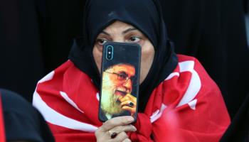 Iranian woman with a picture of Supreme Leader Ayatollah Ali Khameini, Tehran, August 2022 (Abedin Taherkenare/EPA-EFE/Shutterstock)