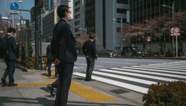 A Japanese salaryman at a crossing point (Nicolas Datiche/SIPA/Shutterstock)