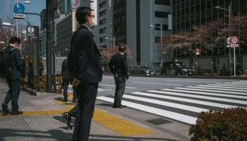 A Japanese salaryman at a crossing point (Nicolas Datiche/SIPA/Shutterstock)