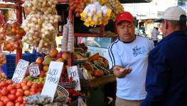 A man sells fruit and veg at a stall in San Jose (Shutterstock/Reimar)