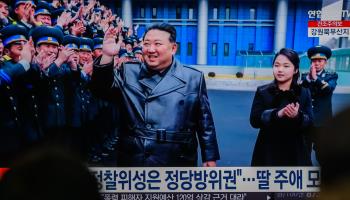 A TV news screen in Seoul showing North Korean leader Kim Jong-un (centre) and his daughter (second from the right) with a group of engineers and scientists who have contributed towards the country’s launch of a reconnaissance satellite (KIM Jae-Hwan/SOPA Images/Shutterstock)