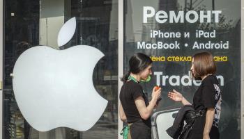 Women talk in front of a window with the Apple company logo and the inscription 'Repair' in Moscow, September 2023 (YURI KOCHETKOV/EPA-EFE/Shutterstock)
