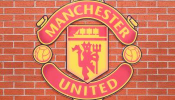 The Manchester United crest on a wall at the club’s Old Trafford stadium (Simon Belcher/imageBROKER/Shutterstock)