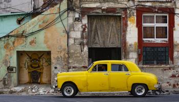A car parked in front of a crumbling building in Havana, Cuba (Yander Zamora/EPA-EFE/Shutterstock)