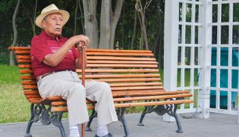An elderly Latin American man on a park bench (Shutterstock)