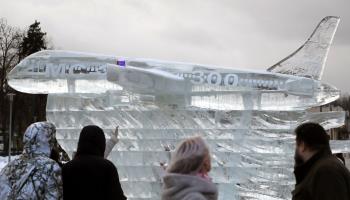 People walk next to an ice sculpture dedicated to the Irkut MC-21 mid-range passenger aircraft (MAXIM SHIPENKOV/EPA-EFE/Shutterstock)