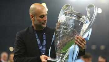 Manchester City manager Pep Guardiola contemplates the UEFA Champions League trophy having just won it, June 10, 2023 (Kieran McManus/Shutterstock)