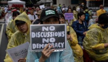 A protester outside of Taipei’s Legislative Yuan holding a placard against contentious reforms (Vernon Yuen/NurPhoto/Shutterstock)