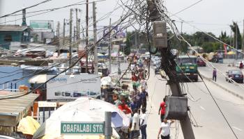 An electric meter fixed to a pole with a haphazard jumble of wires, Lagos, June 2022 (Akintunde Akinleye/EPA-EFE/Shutterstock)
